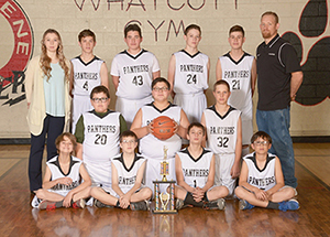 Boys basketball team poses in the gym