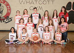 Girls basketball team poses in the gym