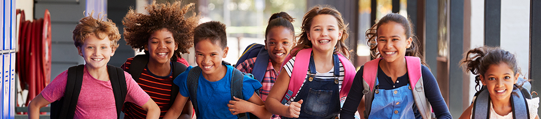 Smiling kids running in elementary school hallway