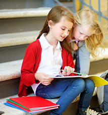 Students sitting on steps looking at a folder together